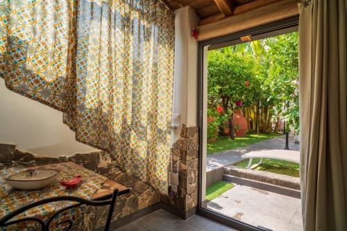 a dining room with a table and a glass door at A Ugghia- Dependance in Fiumefreddo di Sicilia