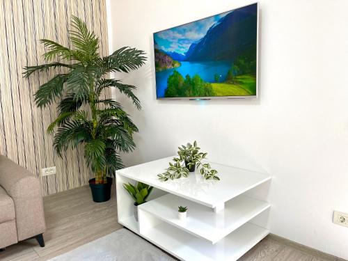 una sala de estar con una mesa blanca y una planta en Cosy place to stay, en Timisoara