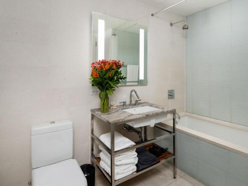 a bathroom with a sink and a vase of flowers at Stunning 2BD Apartment on the 38th Floor in Midtown in New York
