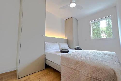 Habitación blanca con cama y ventana en T2 A - Best place in Cala-Montgo beach Apartment with 2 Beds, AC & private Parking, en Torroella de Montgrí