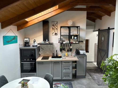 a kitchen with gray cabinets and a counter top at LiMo Apartman in Fonyód