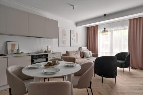 a kitchen and a living room with a table and chairs at APARTIO ROOMS Gliwice in Gliwice
