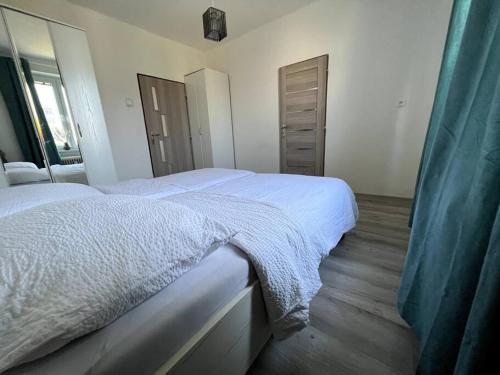 a bedroom with two beds with white sheets and a mirror at Modern, Cozy apartment with Netflix & Free parking 