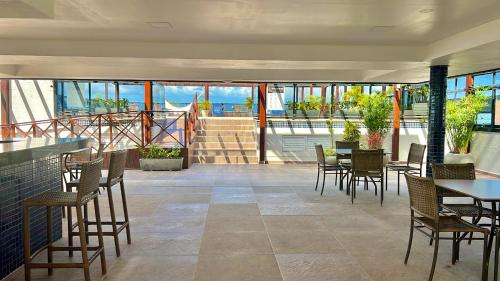 a restaurant with tables and chairs and a balcony at MARINAS PRAIA Flat in João Pessoa