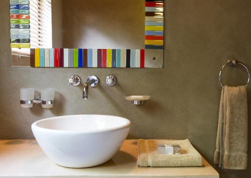a bathroom with a white bowl sink on a counter at Stonehill River Lodge by Dream Resorts in Buffeljagsrivier