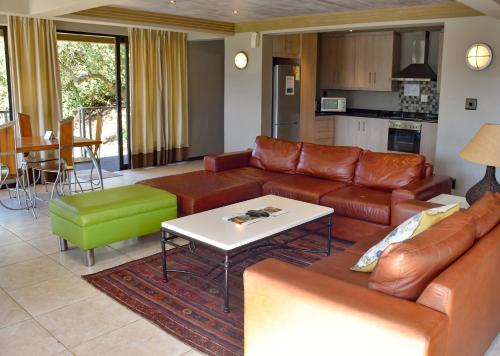 a living room with a couch and a table at Stonehill River Lodge by Dream Resorts in Buffeljagsrivier