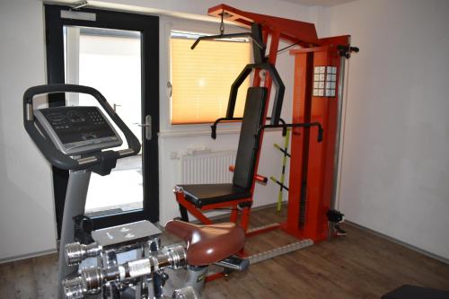 a gym with a treadmill and a chair in a room at Hotel Kleißl in Oberperfuss