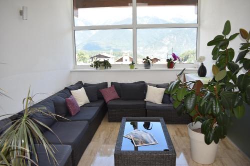 a living room with a blue couch and a table at Hotel Kleißl in Oberperfuss