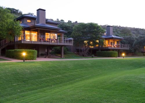 a large house with a green lawn in front of it at Stonehill River Lodge by Dream Resorts in Buffeljagsrivier