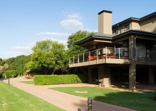 a large building with a balcony and a lawn at Stonehill River Lodge by Dream Resorts in Buffeljagsrivier