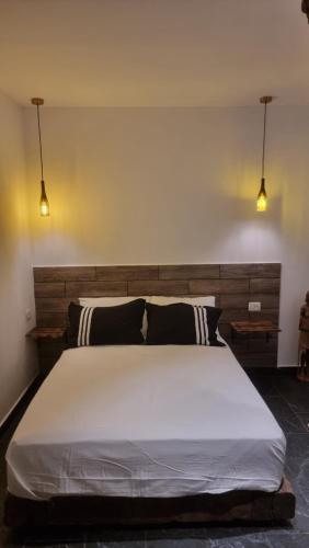 a bedroom with a large white bed with two lights at tree house eilat in Eilat