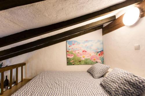 a bedroom with a bed and a painting on the wall at Casa con jardín y terraza privados, cerca del mar in Ea