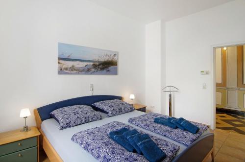 a bedroom with a bed with two blue pillows at Villa Fokken Kapitänsquartier in Esens