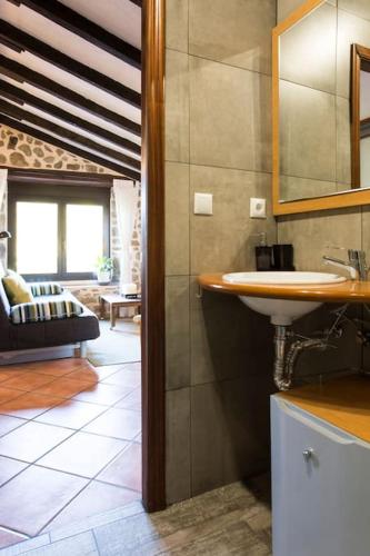 a bathroom with a sink and a living room at Casa Biax jardín y terraza privada junto al mar in Ea