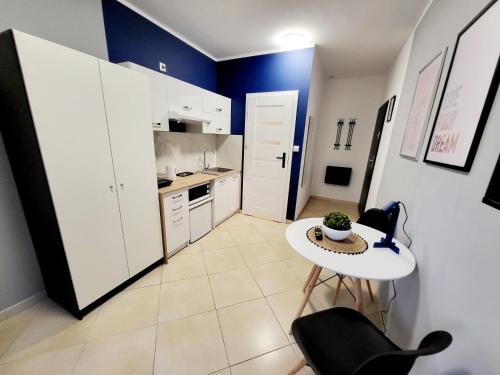 a small white kitchen with a table and chairs at Mini Apartamenty Poznań in Poznań
