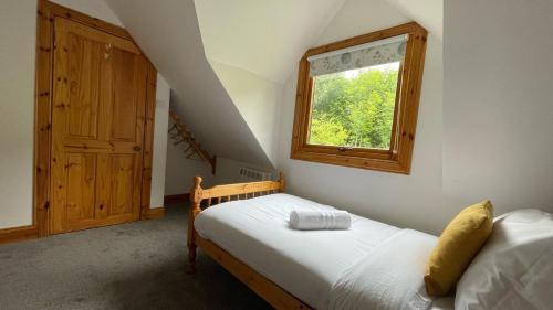 Habitación pequeña con cama y ventana en Kerrowdown Cottage-Self Catering for 4 in the Highlands en Drumnadrochit