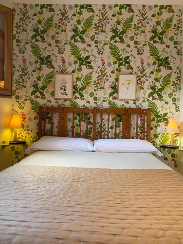 a bedroom with a bed with a floral wallpaper at La Casa de Los Moyas in Olba