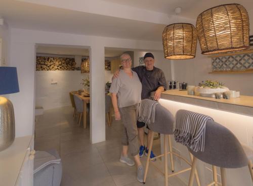 Olive & Ivy Guesthouse في Canillas de Aceituno: رجل وامرأة يقفان على منضدة في مطبخ