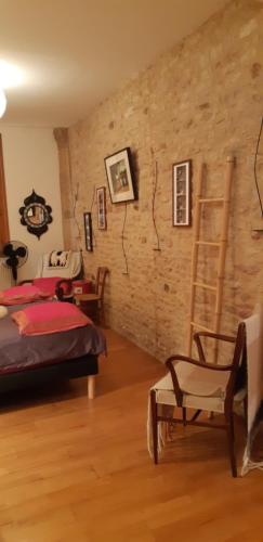 1 dormitorio con cama, escalera y silla en Bell'Accueil Chambres d'Hôtes Cluny, en Cluny