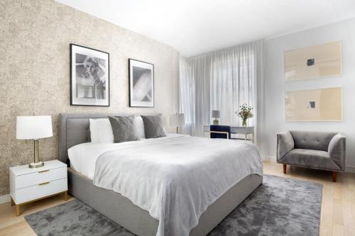 a bedroom with a large bed and a chair at Stylish 1BD near Bryant Park with Washer and Dryer in New York