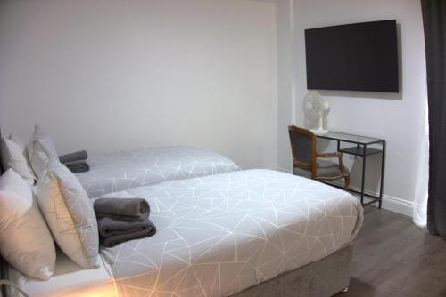 a bedroom with a bed and a desk with a television at Abbey Point Hotel in London