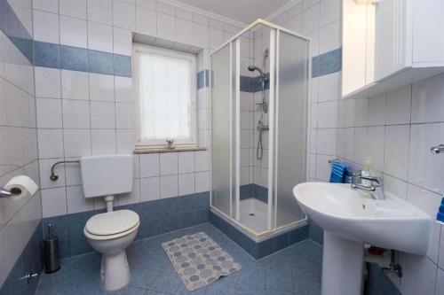 a bathroom with a toilet and a sink and a shower at Apartments Marlen in Mali Lošinj