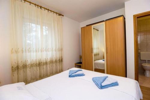 a bedroom with a bed with two blue towels on it at Apartments Marlen in Mali Lošinj