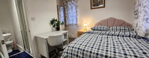 a bedroom with a bed and a desk and a sink at White House Ensuite double bedroom in Warrington