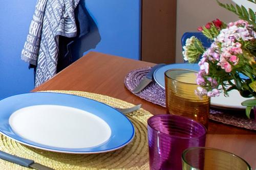 a table with plates and a vase with flowers on it at Residence Scirocco e Tramontana in Favignana