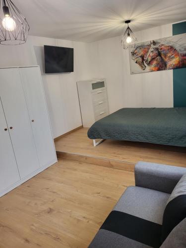um quarto com uma cama, um sofá e uma televisão em PaulAngela em Avignon