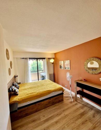 um quarto com uma cama amarela e uma janela em Cagnes sur Mer-Spacieux 2 pièces em Cagnes-sur-Mer
