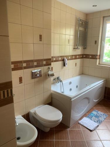 a bathroom with a tub and a toilet and a sink at ORW Rzemieślnik in Międzywodzie