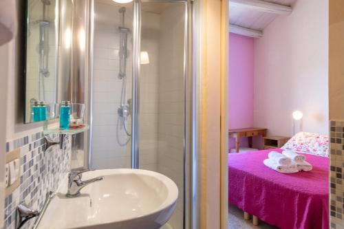 a bathroom with a sink and a shower with a bed at Caelum Hyblae in Ragusa