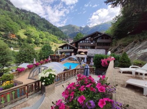 - une vue sur un complexe avec une piscine et des fleurs dans l'établissement Résidence Les Edelweiss, à Champagny-en-Vanoise