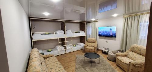 a living room with a couch and chairs and a tv at La Casa EmilioAngi in Yerevan