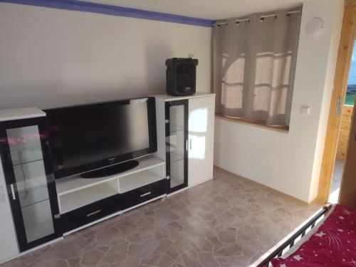 a living room with a flat screen tv and a refrigerator at Nový kemp Slezské Pavlovice in Slezské Pavlovice