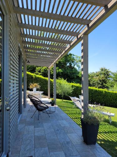 a pergola on a patio with a table and chairs at The Lake House in Viverone