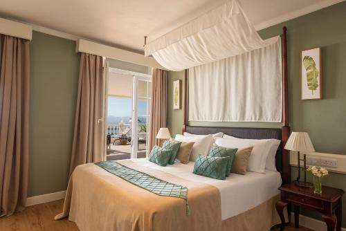 1 dormitorio con 1 cama grande y ventana en Rock Hotel en Gibraltar