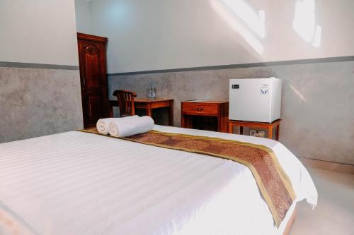 Un dormitorio con una cama con una toalla. en Kubu Indah Homestay Sanur en Sanur