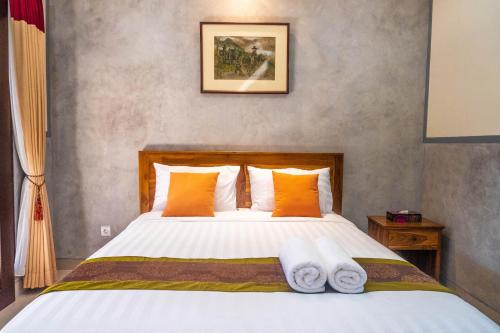 um quarto com uma cama com toalhas em Kubu Indah Homestay Sanur em Sanur