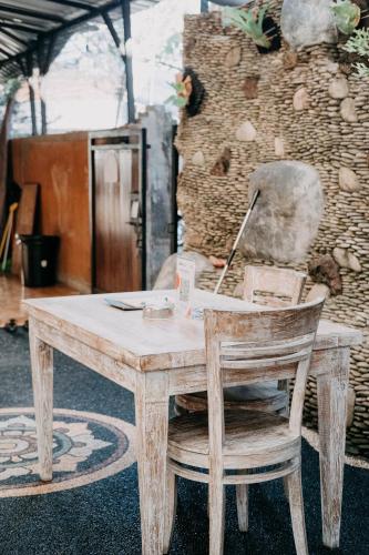 a wooden table and a chair with a laptop on it at Kubu Indah Homestay Sanur in Sanur