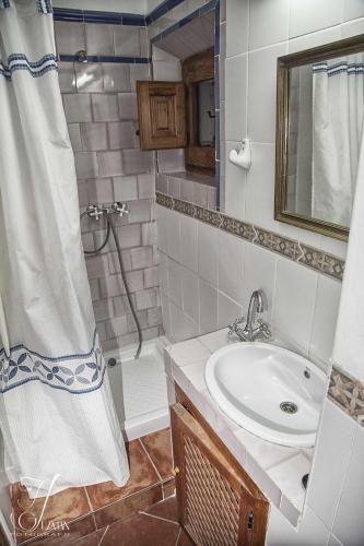 a bathroom with a sink and a shower with a shower curtain at Casa De La Fuente in Bubión