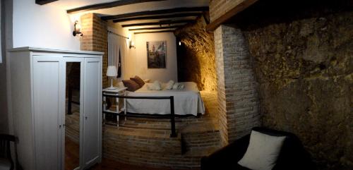 um quarto com uma cama numa parede de tijolos em Studio with wifi at Penaflor em Peñaflor