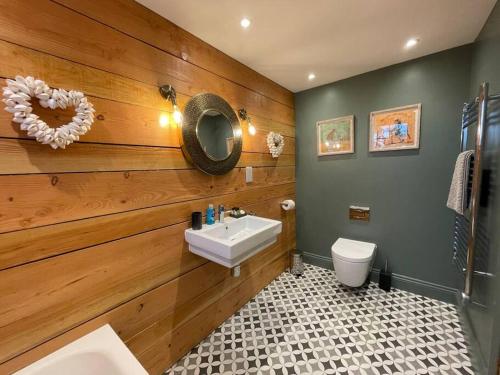 La salle de bains est pourvue d'un lavabo, de toilettes et d'un miroir. dans l'établissement The Old Stables, à Salisbury