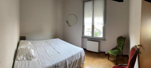um quarto com uma cama branca e uma cadeira verde em Monterosso Val D’Arda em CastellʼArquato