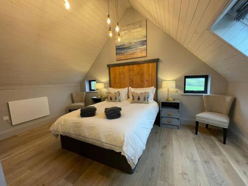 a bedroom with a large bed and two chairs at The Old Stables in Salisbury