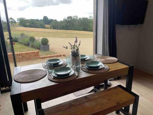 a table with plates and dishes on it with a view of a field at The Old Stables in Salisbury