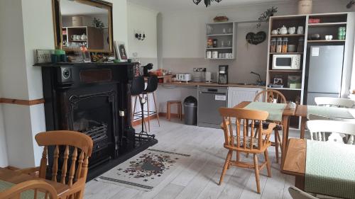 a living room with a fireplace and a table and chairs at Yeats Lodge in Drumcliff