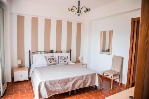 een slaapkamer met een bed en een stoel bij Quattroemme Soc Agricola in Sinagra