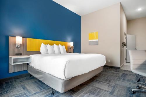 a large white bed in a room with a blue wall at Comfort Inn & Suites Destin near Henderson Beach in Destin